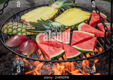 Roasted watermelon on grill grate with fire. Grilled watermelon on ...