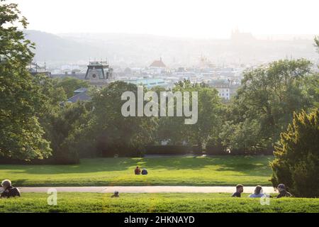 Prague, Czech Republic - June 5, 2009: People sitting in the grass in the Riegrovy sady and enjoying sunny summer evening. Lookout of Prague historica Stock Photo