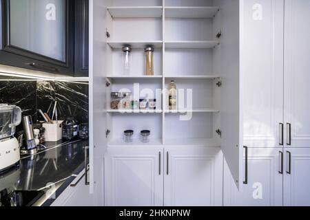 Open cabinets in a new kitchen set. Almost empty shelves. Stock Photo