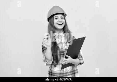 building and construction. happy child worker wear hardhat hold clipboard. childhood development Stock Photo
