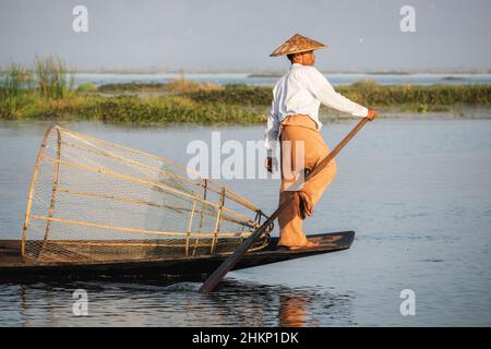 Intha fisherman leg rowing in traditional style on Inle Lake, Shan State, Myanmar (Burma). Stock Photo