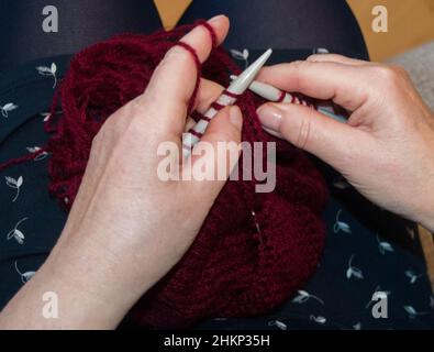 women knitting with dark red wool handmade Stock Photo