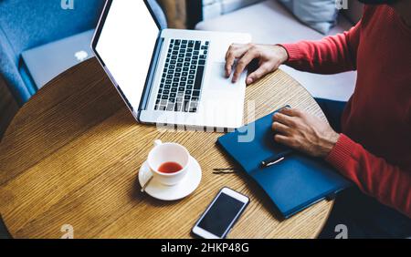 Freelancer working on laptop in cafe Stock Photo