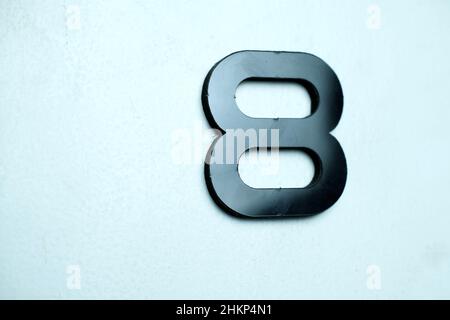 Number eight in black on a light blue background Stock Photo