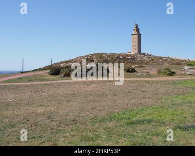Grassy field and tower of Hercules in european A Coruna city at Galicia district of Spain, clear blue sky in 2019 warm sunny summer day on September. Stock Photo