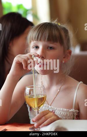 The girl drinks lemonade at the restaurant Stock Photo