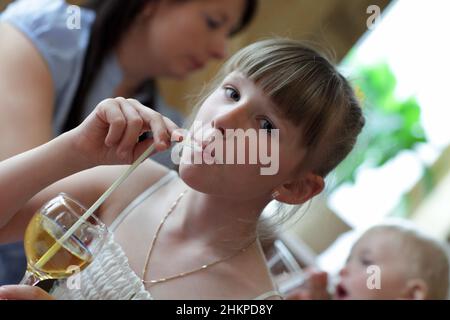 The teen drinks lemonade at the restaurant Stock Photo