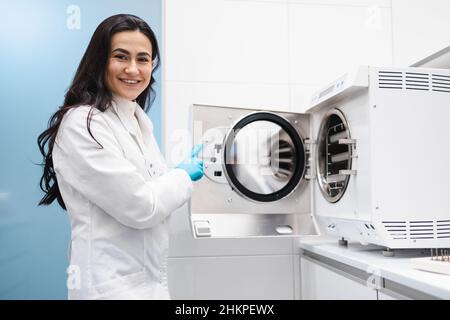 Medical worker in the instrument sterilization room. Doctor assistant working with autoclave Stock Photo