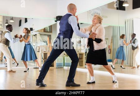 Mature woman dancing swing with young man Stock Photo