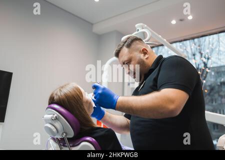 Male dentist working on female patient's teeth Stock Photo