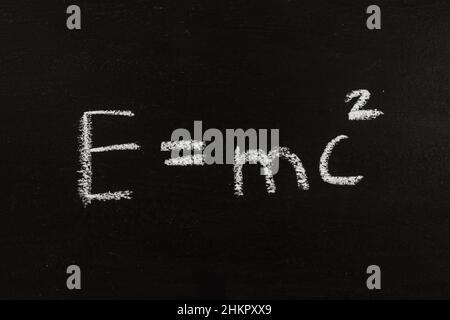 The calculation for mass energy equivalence ist standing on a chalkboard, physic formular Einstein Stock Photo