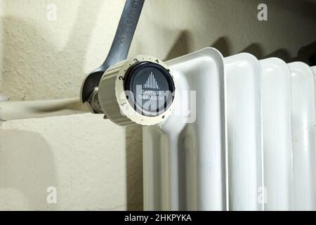 Stuttgart, Germany - February 01, 2022: Replace old Danfoss radiator thermostat valve. Open-end wrench removes component from the heater. Modernizatio Stock Photo