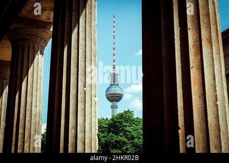 The Fernseh Turm in Berlin seen between old architectural columns on a warm summer day Stock Photo