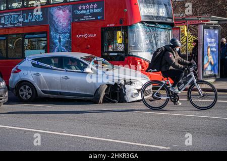 PUTNEY LONDON, UK. 5  February, 2022. A  cyclist rides past a  car taped with police cordon tape  which has been involved in an accident and abandoned on Putney  bridge London. Credit: amer ghazzal/Alamy Live News Stock Photo