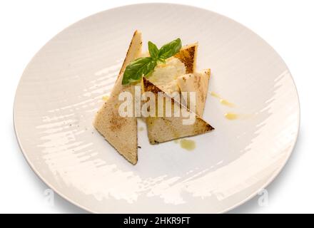 Venetian creamed cod with slices of toast and extra virgin olive oil and basil leaves, in plate on white background Stock Photo
