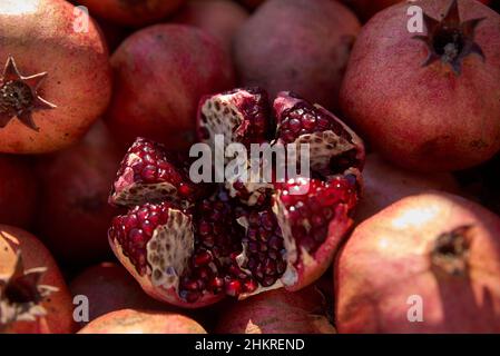 Pomegranate garnet fruit background pattern. Fresh raw organic garnet fruit pile texture background. Ruby natural pomegranate heap close up top view. Stock Photo