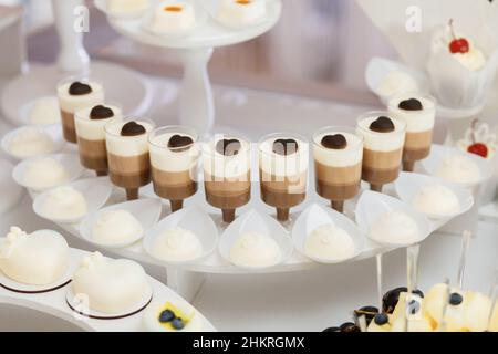 Beautiful desserts in plastic cups, beautifully decorated, candy bar, desserts for a banquet Stock Photo