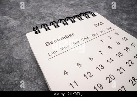 December 2022 - spiral desktop calendar against gray handmade paper, low angle macro shot, time and business concept Stock Photo
