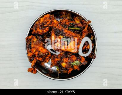 deep-fried chicken varuval in a bowl top view on grey background Stock Photo