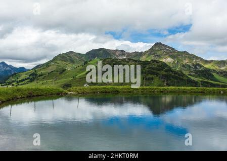 Water reservoir for providing snowmaking to ski slopes in winter in alpen ski resort Obertauern in summer, Radstadter Tauern, Austria Stock Photo