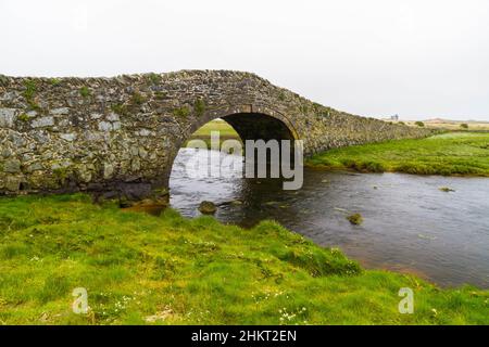 Old hump-backed bridge Pont Pont Aberffraw on Anglesey, Wales UK, landscape Stock Photo