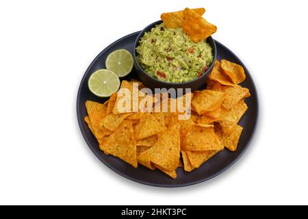Top view of guacamole sauce and tortilla chips or nachos in black plate isolated on a white background Stock Photo