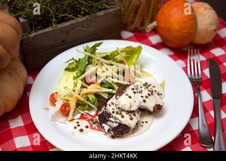 Steak with Creamy Peppercorn Sauce. Fresh salad on the side. Chateaubriand of tender beef and cream sauce with peppers. Stock Photo