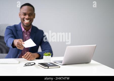 African Business Man Giving Paycheck Or Payroll Cheque Stock Photo