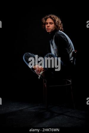 Stylish fashion guy wearing trendy turtleneck sweater, checkered pants and sneakers Stock Photo