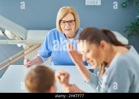 Mother with nervous son in child psychologist Stock Photo