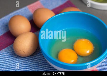 two egg yolks in a blue bowl Stock Photo
