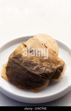 Used Teabag in a small dish on a kitchen counter Stock Photo