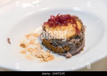 Quiche, pie with onions and almonds, served on porcelain white plate. Stock Photo