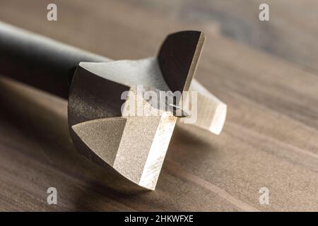 forstner drill bit on the wooden bakground. joiner woodshop Stock Photo