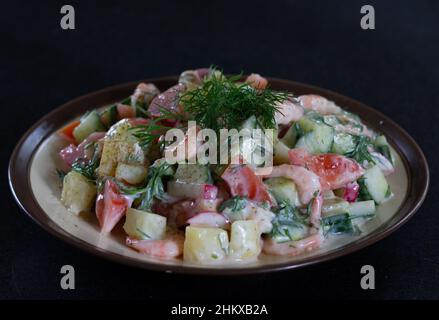 Homemade salad with shrimps and fresh vegetables sauced with yogurt decorated with fennel on plate Stock Photo