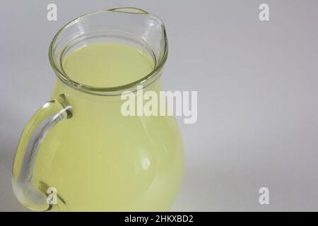 Liquid whey that remains after formation of curds in jar on the white background Stock Photo