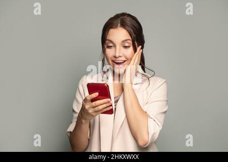 Portrait of young beautyful happy excited woman with phone. Surprised female model with smartphone Stock Photo