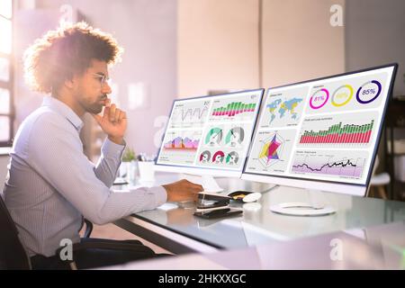African American Financial Analyst Man Using Multiple Computers Stock Photo