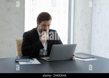 Busy serious business man working at computer in office Stock Photo