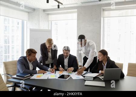 Diverse business team discussing project reports, marketing strategy Stock Photo