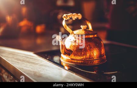sunny daylight from the window shines on a beautiful copper teapot. Stock Photo