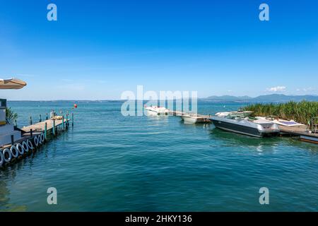 Small port on the coast of Lake Garda with speedboats between the village of Lazise and Bardolino, tourist resorts in Verona province, Veneto, Italy. Stock Photo
