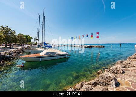 Small port of village of Cisano with small boats moored. Tourist resort on the coast of Lake Garda. Bardolino municipality, Verona, Veneto, Italy. Stock Photo
