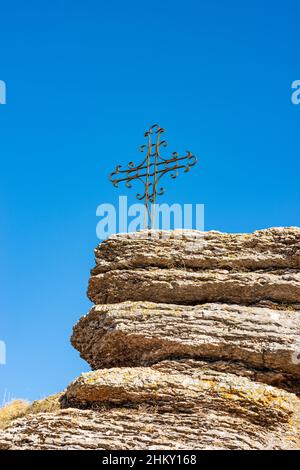 Karst formations on Lessinia Plateau Regional Natural Park and a wrought iron religious cross. Erbezzo municipality, Verona, Veneto, Italy, Europe. Stock Photo