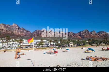 Camps Bay Beach with sun bathers and Twelve Apostles Mountain Ranges of Table Mountain in the background, in the outskirt of Cape Town, South Africa. Stock Photo
