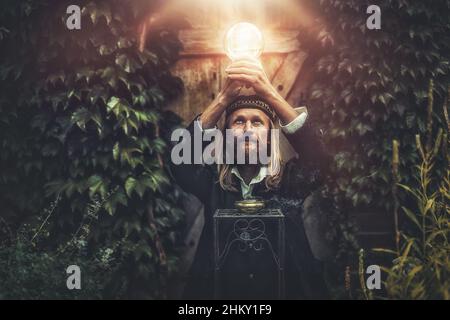 Alchemist in a beautiful ornamental dress in nature. Stock Photo