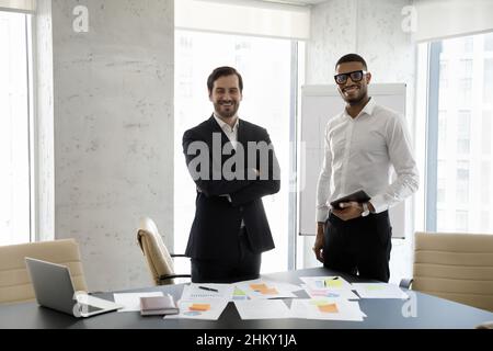 Happy diverse business project partners enjoying teamwork over paper reports Stock Photo