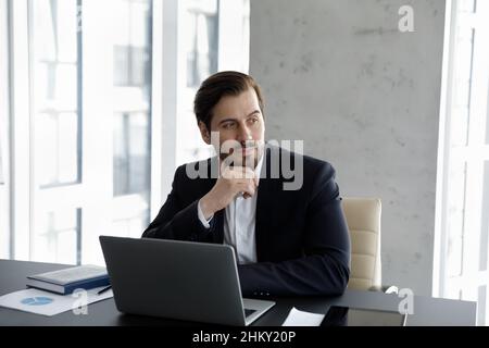 Thoughtful serious business leader working at computer in office Stock Photo