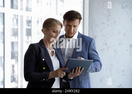 Confident engaged boss instructing employee, telling about task Stock Photo