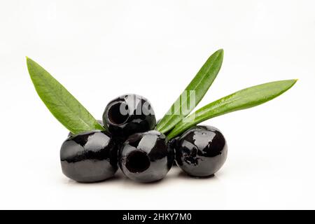 Black olives with olive leaves on white background Stock Photo